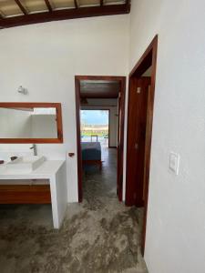 a bathroom with a sink and a mirror at Os Navegantes - Casa Mar in Amontada