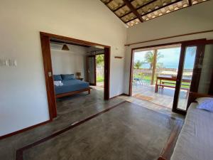a bedroom with a bed and a sliding glass door at Os Navegantes - Casa Mar in Amontada
