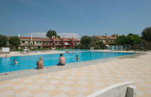 a group of people sitting in a swimming pool at Villaggio Michelangelo in Bibione