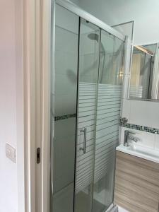 a bathroom with a glass shower and a sink at Habitaciones IFAE in Alcalá