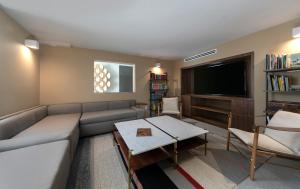 uma sala de estar com um sofá e uma televisão em La Jolla Cove Suites em San Diego