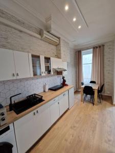 une cuisine avec des placards blancs et une table. dans l'établissement Appartement au cœur de ville, à Chalon-sur-Saône