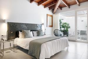 a white bedroom with a large bed and a balcony at THE CLUB - Accommodation - Dining - Events in San Miguel de Abona