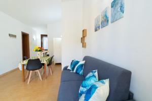 a living room with a blue couch and a table at Casa al Vicolo 99 in Birgi Vecchi