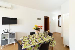 a dining room with a table with a vase of flowers on it at Casa al Vicolo 99 in Birgi Vecchi +19 photos