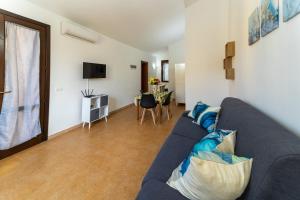 a living room with a blue couch and a table at Casa al Vicolo 99 in Birgi Vecchi