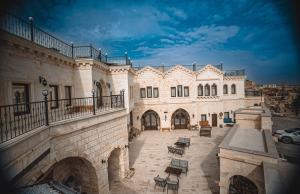 ein großes Gebäude mit einem Balkon und einem Innenhof in der Unterkunft Nujel'm Cappadocia in Ürgüp