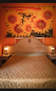 1 dormitorio con una pintura de girasoles en la pared en B&B Candalla, en Camaiore