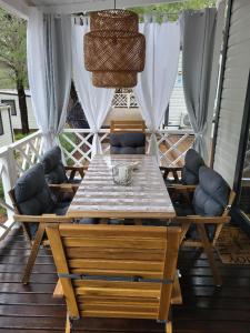 a wooden table and chairs on a deck at Mobilheim ANDREA wunderschöne Ferienwohnung direkt am Meer in Jezera