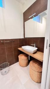 a bathroom with a sink and a counter with baskets at Casa Adriana in Siracusa