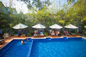 a group of people sitting in a swimming pool at La Mer Resort, Phú Quốc in Phú Quốc