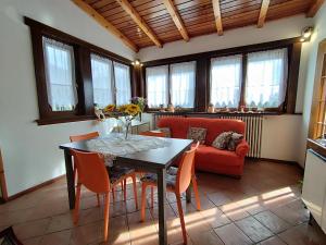 uma sala de estar com uma mesa e um sofá vermelho em Villa Salagona em Laggio