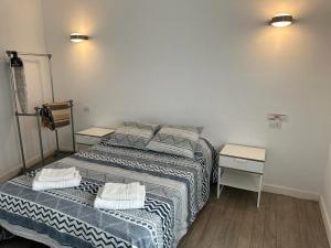 two beds in a room with two night stands at Habitaciones IFAE in Alcalá