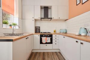 a kitchen with white cabinets and a sink at 10 Percent OFF - 3 Nights - Leeds - Bradford - Free Parking in Bradford