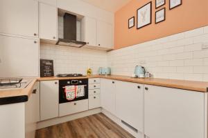 a kitchen with white cabinets and a stove at 10 Percent OFF - 3 Nights - Leeds - Bradford - Free Parking in Bradford