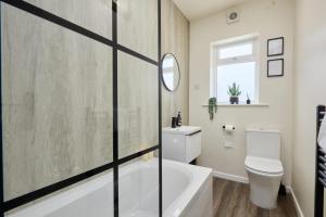 a bathroom with a tub and a toilet and a sink at 10 Percent OFF - 3 Nights - Leeds - Bradford - Free Parking in Bradford