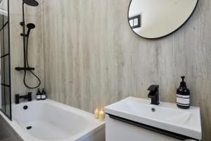 uma casa de banho com um lavatório branco e um espelho. em 10 Percent OFF - 3 Nights - Leeds - Bradford - Free Parking em Bradford
