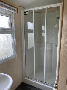 a bathroom with a shower and a white sink at Golden Palm Resort TM5 in Chapel Saint Leonards +22 photos