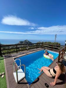 une femme qui se couche sur une terrasse dans une piscine dans l'établissement B&B Roomantic & Piscina Idromassaggio, à Cefalù