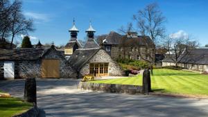 uma grande casa de pedra com um jardim relvado em Bonny Vista em Inverness