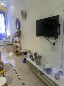 uma sala de estar com uma televisão de ecrã plano na parede em Appartement 2 à Carthage byrsa em Douar ech Chott
