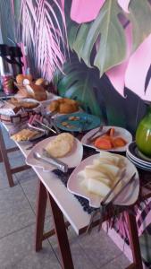 uma mesa longa com pratos de comida em Caminho do Sol Pousada em Chapada dos Guimarães