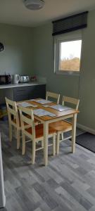 a dining room table and chairs in a kitchen at Grenada Garden Lodges in Ingoldmells
