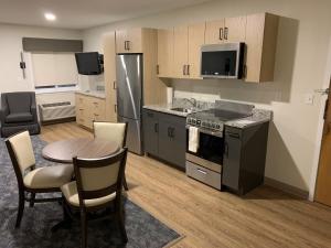 a kitchen with a table and a stove and refrigerator at Residences at Solomon Pond in Marlborough