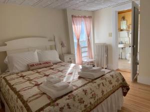 ein Schlafzimmer mit einem Bett mit Handtüchern darauf in der Unterkunft The Cornish Inn in Cornish