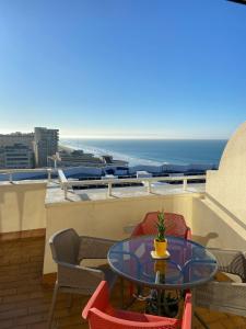カディスにあるAtico Apartamento Loft Playa Victoria Cadizのテーブルと椅子、海の景色を望むバルコニー
