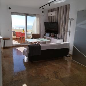 カディスにあるAtico Apartamento Loft Playa Victoria Cadizのベッドルーム1室(ベッド1台付)、リビングルームが備わります。