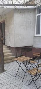 a picnic table and two chairs in front of a building at Центрові апартаменти in Ivano-Frankivsʼk