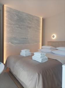 a bedroom with two beds with white towels on them at Sileo Apart No.85 in Ustka