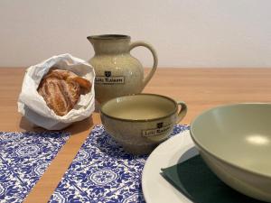 La Casa degli Alberi في دولشياكا: طاولة مع وعاء من الخبز و مزهرية