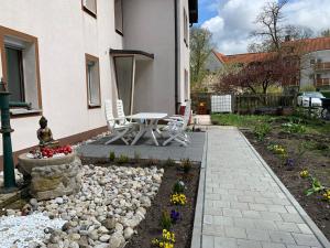 a patio with a table and chairs in a garden at Diyo Apart Festspiel Bayreuth in Bayreuth