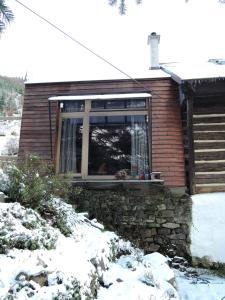 una casa con una ventana en la nieve en Atelier Eliska, en Staré Hory