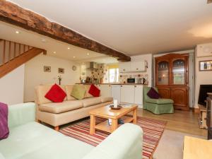 uma sala de estar com um sofá e uma mesa em Apple Cottage em Crediton