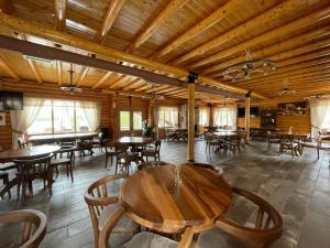 uma sala de jantar com tectos e mesas e cadeiras de madeira em Resort Mezini em Ersekë