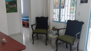 a living room with two chairs and a table at Cabaña Campestre in La Pintada