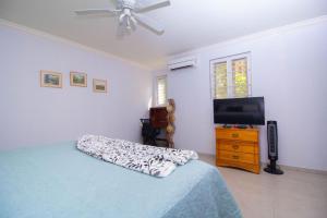 a bedroom with a bed and a flat screen tv at Crystal Cove Oceanfront/ 2 bedroom Condo in Ocho Rios