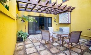 eine Terrasse mit einem Tisch und Stühlen sowie ein Gebäude in der Unterkunft Crystal Cove Oceanfront/ 2 bedroom Condo in Ocho Rios