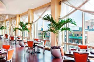 restauracja ze stołami i krzesłami oraz dużymi oknami w obiekcie Sheraton Atlantic City Convention Center Hotel w Atlantic City