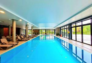 duży basen w budynku z krzesłami w obiekcie Rest Luxury Apartments w Kołobrzegu