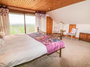 a bedroom with a bed and a large window at Higher Kernick Farm in Launceston