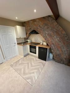 uma cozinha com uma parede de tijolos e uma bancada em Modern En-Suite Rooms Town Centre Self-Check In em Barnsley