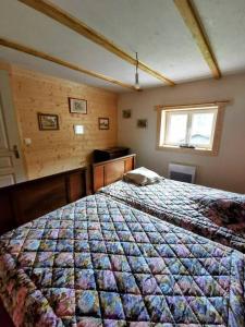 um quarto com uma cama com uma colcha em LA GRANGE AUX 5 SENS em Walscheid