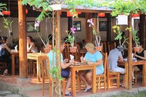 a group of people sitting at tables in a restaurant at La Mer Resort, Phú Quốc in Phú Quốc