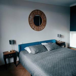 sypialnia z niebieskim łóżkiem i lustrem w obiekcie Magnifique appartement avec vue cité! w Carcassonne