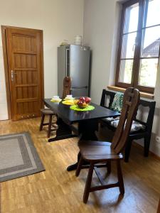jadalnia ze stołem i krzesłami oraz talerzem owoców w obiekcie Spalskie Pokoje Gościnne w Spale