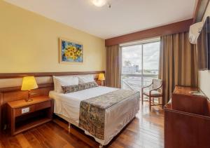 ein Hotelzimmer mit einem Bett und einem Fenster in der Unterkunft Ritter Hotéis - Em frente à Rodoviária de Porto Alegre in Porto Alegre